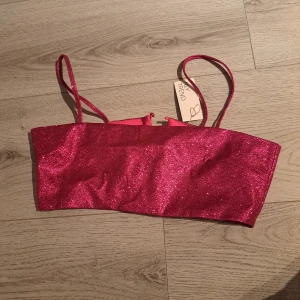 Rosa glittrig festtopp från nelly - Oanvänd festtopp från nelly. Säljes för den var för stor