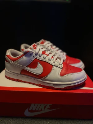 Nike dunk low championship red - Säljer ett par Nike Dunk Low Championship Red. Dom är i väldigt fint skick, och använda sparsamt.