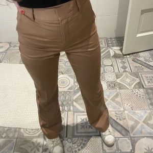 Bootcut kostymbyxa - Brun/Beige/orangea kostymbyxor från NA-KD🧡storlek XS med hög midja och uthängda ben. Skulle säga att den är något stor i storleken. Använda max 2 gånger så ser nya ut! Skriv för mer info eller fler bilder❣️