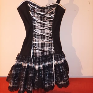 Phaze Clothing Corset Dress - Tror ej du kan få tag på en sån här nånstans.  Storlek XS, Jättefin stål-korsett klänning med inbyggd tyllkjol från Phaze Clothing🖤svart, spets, rutigt, snörning och volanger. Dragkedja baktill. Säljer för att den är för tajt för mig.