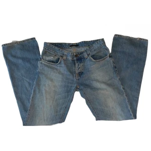 Jeans - LJUSBLÅA JEANS FRÅN NUDIE JEANS  MODELL: Bootcut Ola.           MATERIAL: 100% bomull              Skick: Byxorna är i bra skick och har inga defekter.  Mått: Midjemåttet är 83cm och innerbensmåttet är 80cm