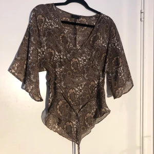 Flare-sleeve tie top strl 40 - I gott skick utan tecken på användning, från märket Lindex (retro). Paisley print, skir icke-stretchigt material i strl 40/M