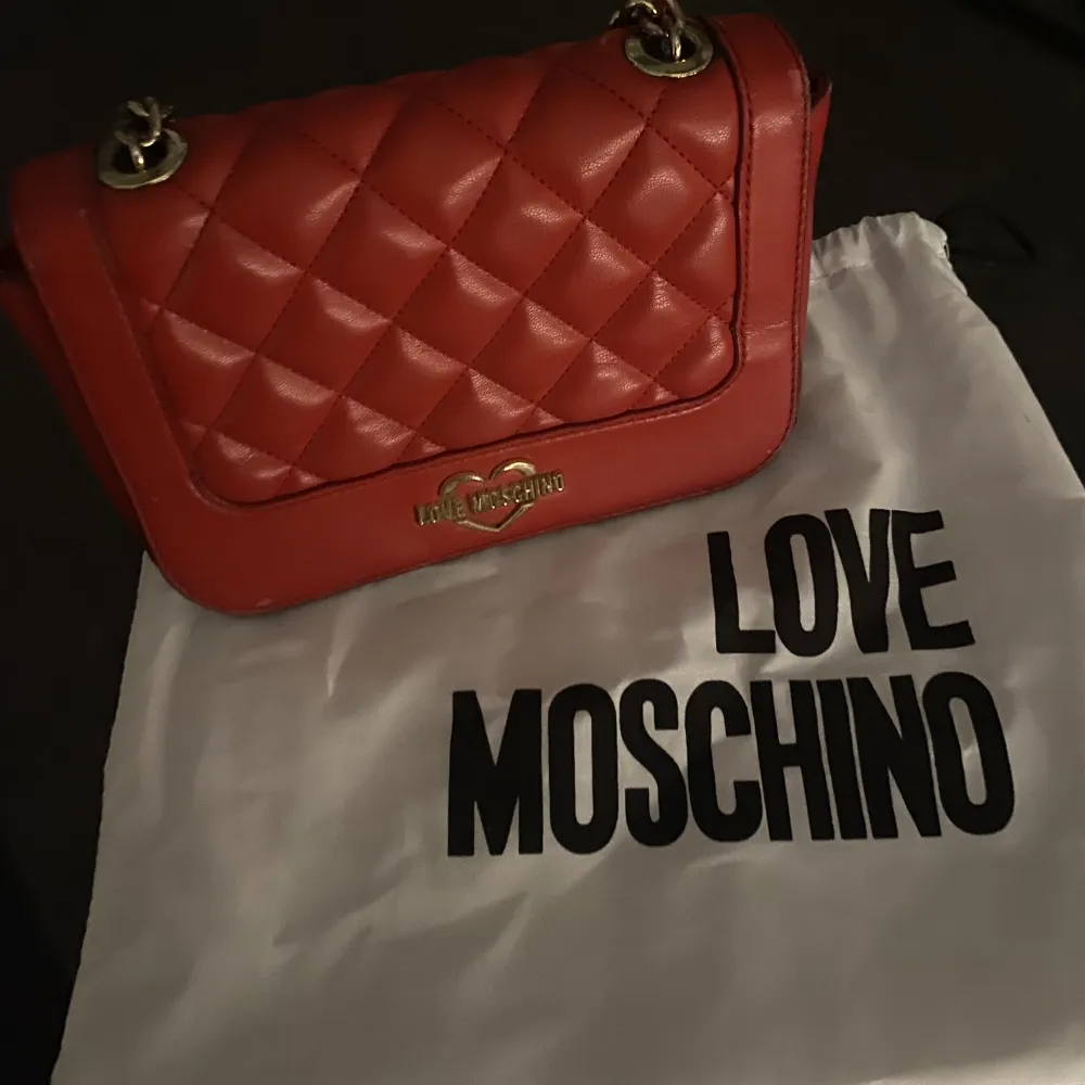 skitsnygg röd väska från moschino!! väskan är använd men ändå i fint skick! säljer den för den inte längre kommer till användning!!. Väskor.