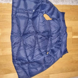 Tommy Hilfiger väst - En fin dunväst från Tommy hilfiger, ganska stor i storleken (164) skulle säga att den passar en small beroende på längd osv