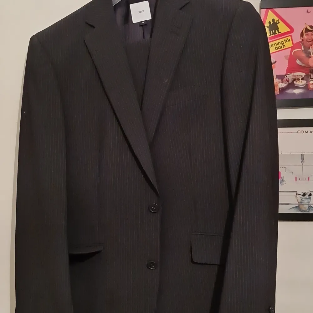 Bläck kritstrecksrandig svart kostym, välbehållen storlek 46 eller small, engelskt snitt, knäppning 2 knappar, 6 fickor.. Kostymer.