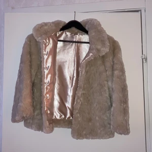Fuskpälsjacka - Snygg och mysig fuskpäls med siden på insidan. Storlek saknas men rätt liten, ca 34 eller XS. Säljer pga att den ej kommer till användning. Fint skick. Möts upp i Sthlm eller så står köpare för frakt.
