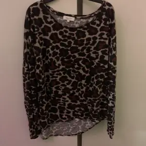 en långärmad leopardmönstrad tröja