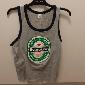 Heineken linne - Heineken linne. Köpt i Thailand 2016. Står XL som storlek men är mer som L. Man får tänka en mindre än vanligt när det gäller Thailand 😜