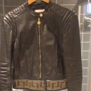Skinnjacka Versace by HM - Skinnjacka från Versace by Hm i storlek 42. Har haft den på mig cirka 10 gånger. Har hängt i min gadrobe väldigt länge nu. 