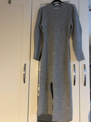 Adoore stickad klänning - Grå stickad klänning från Adoore i modell Verbier. Storlek 38, normal i storlek. 