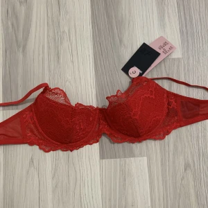 Röd spetsbh  - Röd spetsbh som aldrig är använd med lappen kvar.