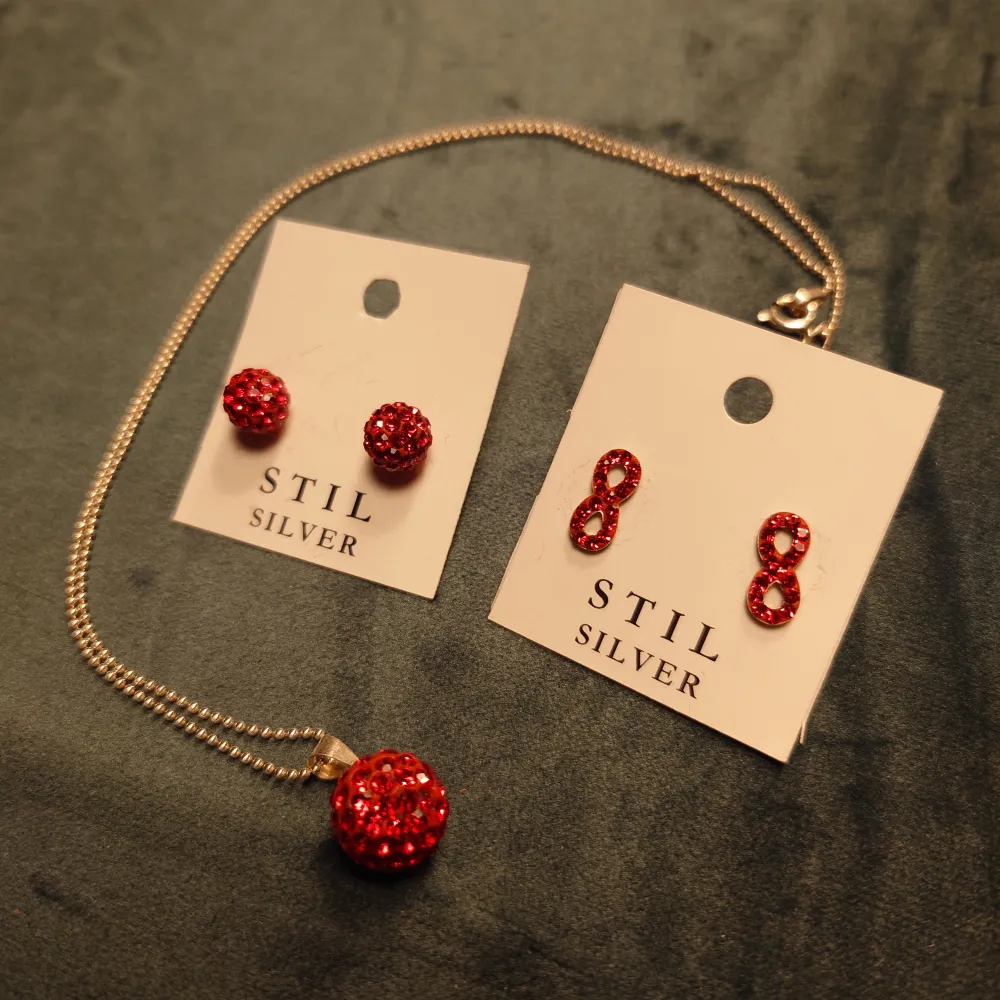 Ett set av halsband och örhängen i rött från Stil Silver. Halsbandet hänger ned ca 22cm, se sista bild.  Oanvänt och i nyskick! Perfekt present.. Accessoarer.