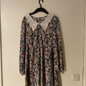 Blommig klänning med spetskrage stl 34 - Jättefin klänning, passar både på vardag och fest. Mellanlång (över knäna)