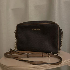 Michael Kors axelbandsväska - En Mikael kors väska äkta som har några år på nacken. Har varit en favorit länge och har därför slitage på en del ställen, kan lagas såklart om man vill och orkar. Rymmer mycket och är väldigt klassisk. Lite färgbortfall på kedjan också.