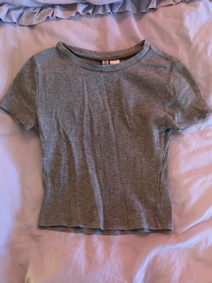 Grå croptop - En vanlig ribbad grå magtröja. Sitter fint på! Bra skick :)