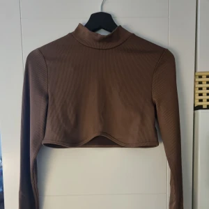 Croppad topp - Oanvänd croppad topp med halvpolo.