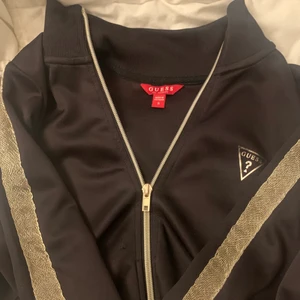 Guess kofta - En svart guess kofta som ja inte använder därav säljer, i ett super skick då jag använt den endast få gånger, guld detaljer på sidan av båda ärmarna och märket på bröstet💓 gratis frakt ! 
