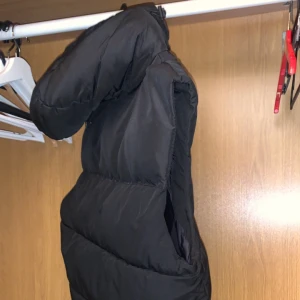Svart Puffig väst - Hej! Säljer min svarta väst med luva! Den är riktigt varm. Storlek S på den men kan även användas till M. Inga skador tillkommer på västen mvh 