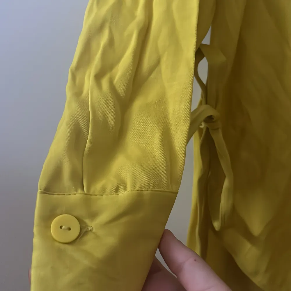 En gul Skjorta/klänning som har två söta band som kan knytas. Oanvänd och i bra skick. . Skjortor.
