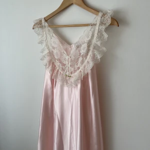 Vintage rosa nattlinne/neglige - Supersöt klänning/nattlinne/neglige i rosa satin med spetsdetaljer och blommor. Vintage men i superfint skick! Uppskattar den som en XS-M, jag ger gärna mått! 