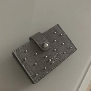 En mörkgrå plånbok med silvriga nitar ifrån Victoria’s Secret. Denna plånbok är i nyskick då den inte är använd mer än två gånger! Säljer den då den inte kommer till användning längre<33