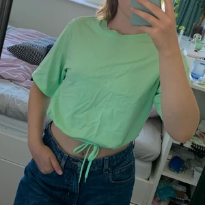 T-shirt neongrön - T-shirt i en härlig neongrön färg från Monki. Den har även snören så man kan göra tröjan tightare, det blir en nice detalj. Annars kan man också vika in snöret så det inte syns;)