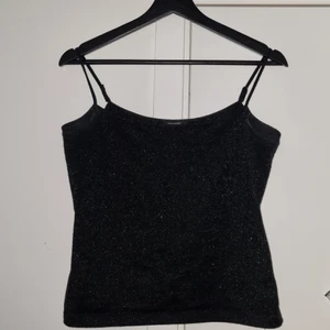 Glittrig Linne - Ett svart glittrigt linne från Vera Moda i storleken L, dock känns det som en M. Har sytt in linnets "snören", men dem är lätta att spreta up. Köparen står för frakten :)  Tar gärna swish 