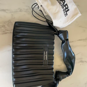 Karl Lagerfeld clutch  - Säljer för köpt en annan och retur tiden gått ut. Mycket fin, ny pris 3100kr så ett kap. Påse medföljer. Kan skickas och mötas upp.   Mått 22x35, vid 6, handtag (avtagbart) 16