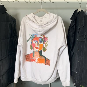 Hoddie med tryck strl M - Hoodie med egenmålat tryck som ger färg i vardagen. Tröjan är sen innan köpt secondhand. 