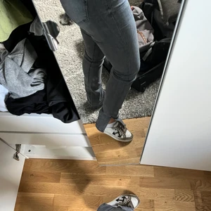 Jeans med slits  - Gråa jeans med slits vid foten! Knappt använda