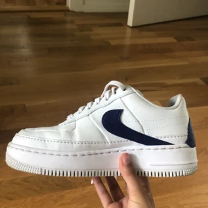 Air Force 1s - Vita AF1s med blått asymmetriskt märke. Användt typ 3 gånger. Har knappt några väck alls.