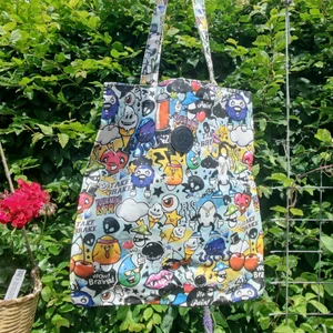 Väska  - Cool vattentät totebag med massor av roliga motiv. Bra skick. Kan både skicka spårbart och icke spårbart.