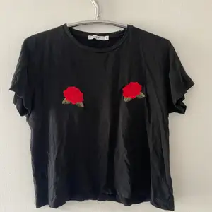 Svart T-shirt med rosor, från NA-KD i storlek S. Fint skick. 😇 Köparen står för frakten. 📦