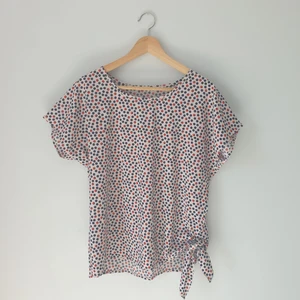 Prickig tröja med rosett - En prickig tröja med rosset. Kylande material.