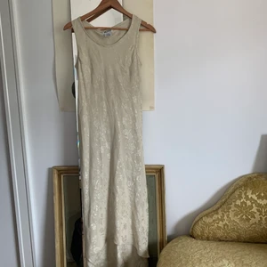 vintage klänning  - beige vintage klänning med underbart slay blommönster. skiner väldigt fint i solen.  märke och storlek lite oklart med passar mig som är s-m, se bild på etiketten. 