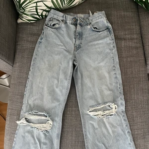 Zara ljusblå straight highwaist jeans - Ljusblåa jeans från zara med hål på knäna. Jeansen är väldigt långa men har ingen söm där nere vilket betyder att det går superbra att klippa det till sin egna perfekta längd! De är i storlek 38 men passar också 36. Du står för frakten.