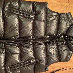 Väst Moncler - Svart Monclerväst  Stl 10-11 år Mkt bra skick Köpt på Monclerbutiken i Stockholm Hämtas av köparen. Kan även skickas med PostNord om köparen står för frakten.  