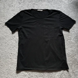 Nudie Jeans T-shirt - Svart T-shirt från de populära jeansmärket Nudie Jeans. Mycket sparsamt använd så egentligen inga tecken på användning. 