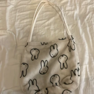 Väska - En fin liten tygväska med kaniner på. Den är köpt från shein och använd em del därför lågt pris, vill bli av med den.