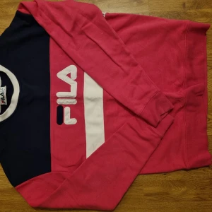 Fila tröja  - Rosa blå vit-randig fila tröja. Bra skick, nästan inte använd alls! Stl S (men tror det är men's size) och sitter lite oversize