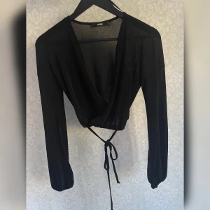 Omlott croptop - Svart kort omlott top, fint loose ärmar, shiny tyg. Bra skick
