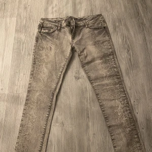 Jeans  - Gråa lågmidjade jeans med detaljer längst benen, stretchiga med ändå lite ”tajtare” i storleken.  Tryck inte på köp direkt utan kontakta mig först, köparen står för frakten!  