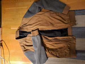 Zara man "collagetröja" - Lite tjockare "collagejacka" av Zara Man, använd till och från men välskött och i mycket gott skick. Bruna textilen är ett fint material som liknar och beter sig som mocka men som kan tvättas som ett vanligt plagg. Tunt fodrad med innerfickor, fråga på! 