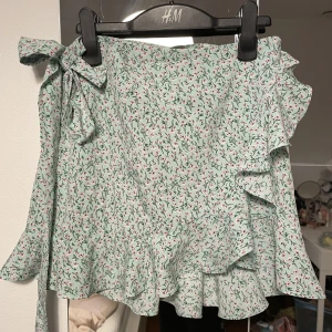 Omlottkjol  - Omlottkjol med volanger i så fina färger! Passar olika storlekar då man kan knyta löst eller hårt. Aldrig använd💘