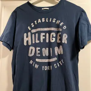 Snygg marinblå T-shirt från Hilfiger Denim i storlek L. Fint skick!