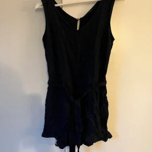 Marinblå jumpsuit  - Marinblå jumpsuit med knyte runt midjan, använd 1 gång Frakt tillkommer 