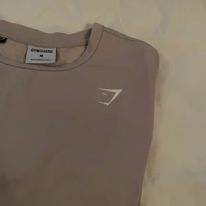 BEIGE TRÄNINGS-T-SHIRT FRÅN GYMSHARK STRL. M - Säljer min beiga träningstisha från gymshark i storlek M. Kan även frakta mot ett billigare fraktalternativ. Garderobsrensning. ❤️