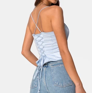 Ljusblå topp med knyte  - Ljusblå topp med knyte från Motel, toppen är aldrig använd och därmed sitter lappen kvar💕 Frakt ingår ej🥰