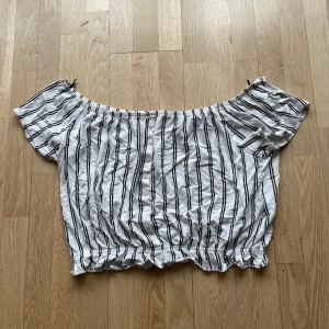 Randig magtröja ifrån hm  - En svart och vitrandig magtröja ifrån H&m i storlek s. Den har resår i botten och sitter åt lite mer där, ärmarna kan justeras för att sitta på axlarna eller lite längre ned på armen. Längd: 32 cm. Fler bilder kan fås och den kan skickas 