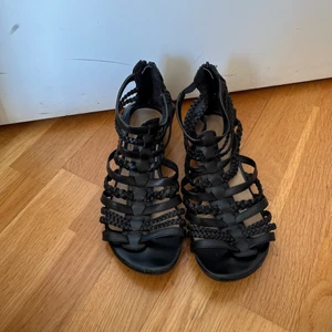 Svarta sandaler - Svarta sandaler med dragkedja. Dragkedjorna funkar som de ska. Köparen står för frakten.